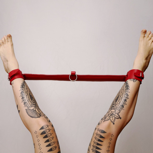 Barre d'écartement en cuir rouge, idéale pour contraindre de multiples façons.