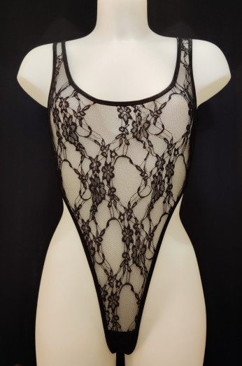 Body string très échancré en dentelle transparente. Son décolleté rond met en lumière la poitrine tandis que sa coupe échancrée dévoile les hanches.