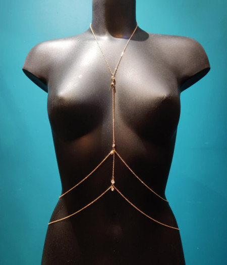 Bijou de buste en chaîne fine dorée avec double chaînes qui tombent sur les hanches et marquent la taille et pendant brillants.