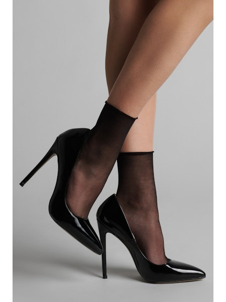 Chaussettes en voile soyeux, finition coupé-roulé sur le bas de la jambe. Elles habillent les pieds et les chevilles.