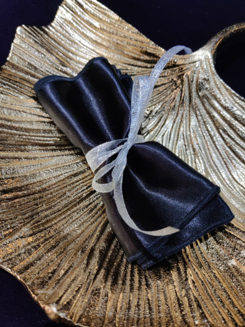 Bandeau fait main en satin noir. Sa longueur d'1m20 environ permet de l'utiliser pour bander les yeux ou lier les poignets.