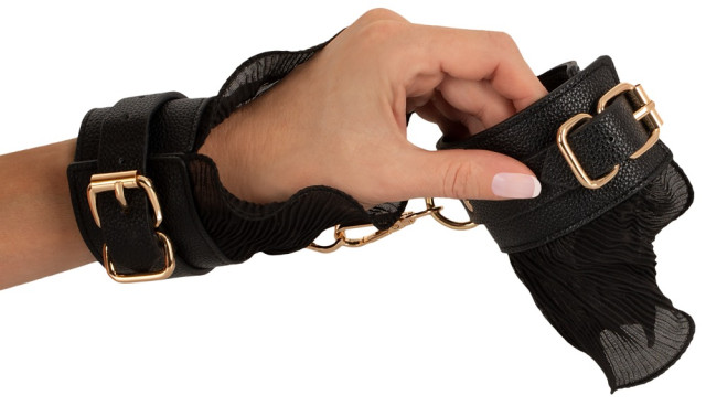 Une jolie paire de menottes en similicuir et tulle pour des jeux bdsm tout en élégance.
