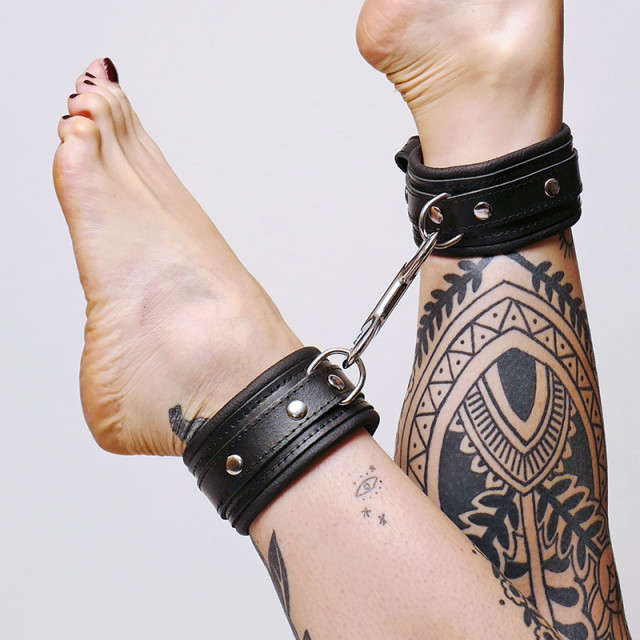 Chevillères noires en cuir molletonné avec son mousqueton en acier pour contraindre de multiples façons.