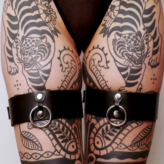 Une paire de menottes pour cuisses en cuir pour intensifier le plaisir lors des jeux de contrainte.