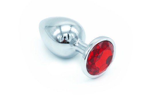 Un plug anal avec son brillant rouge, idéal pour la préparation à la pénétration anale.